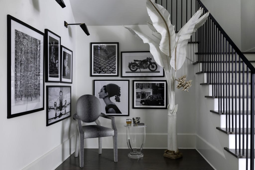 A gallery wall of black and white photos, artwork in a Houston home